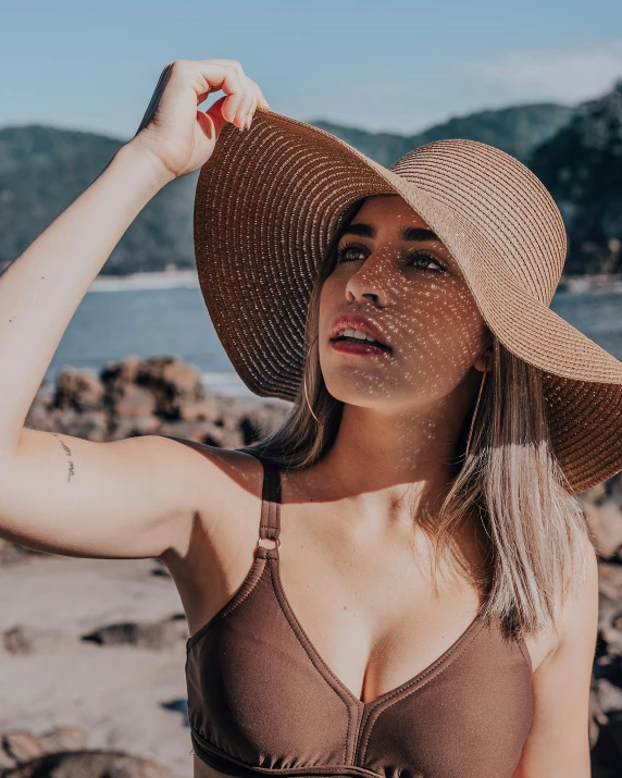 a woman in a bikini and hat on the beach, pexels contest winner, renaissance, her skin is light brown, non binary model, perfectly shaded face, ellie victoria gale