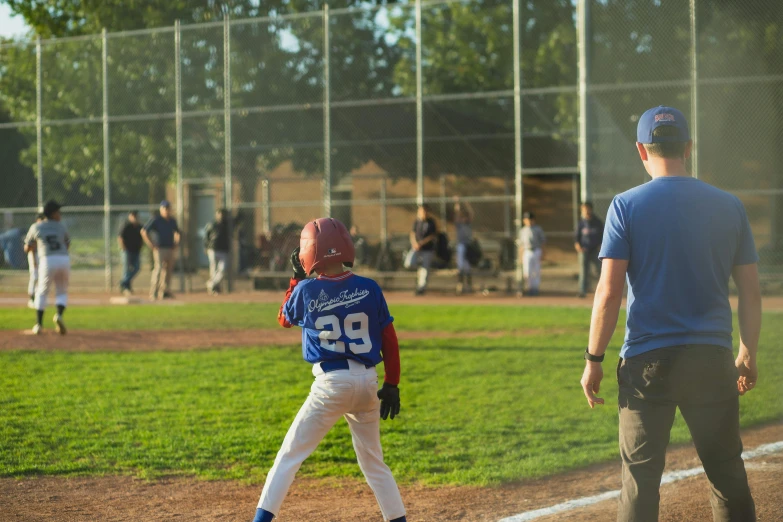 a young boy standing on top of a baseball field, pexels contest winner, person in foreground, sumerville game, walking towards the camera, tournament