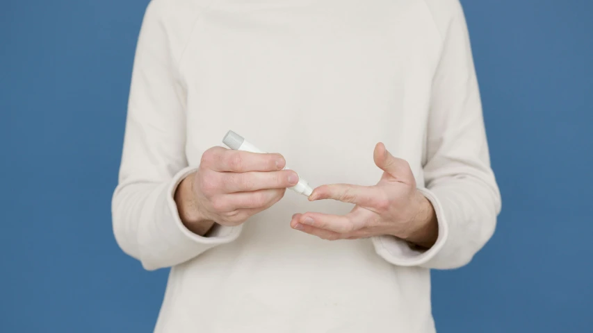 a woman holding a toothbrush and toothpaste in her hands, inspired by Agnes Martin, unsplash, visual art, offering the viewer a pill, unclipped fingernails, white and pale blue, liquid interface