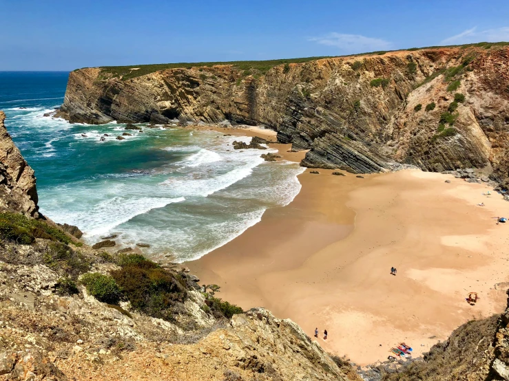 a group of people standing on top of a sandy beach, portugal, beach is between the two valleys, travel guide, hziulquoigmnzhah