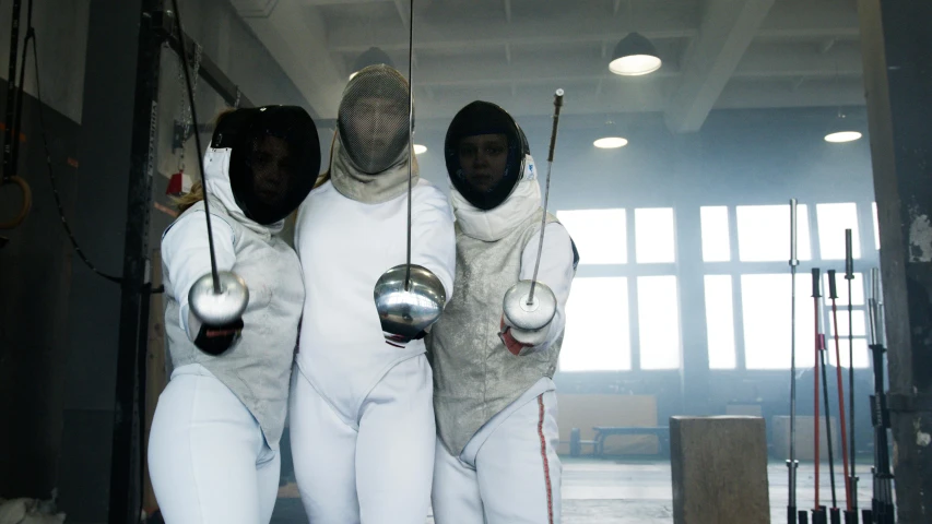 a group of fencers standing next to each other, pexels contest winner, still from a music video, female, freezing, adult swim