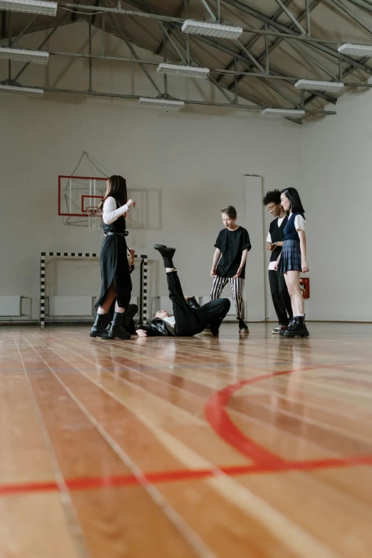 a group of people standing around a basketball court, an album cover, unsplash, ashcan school, goth people dancing, ( ( theatrical ) ), te pae, in the high school gym