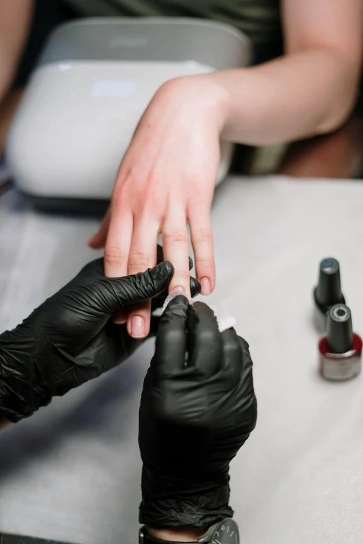 a woman getting her nails done at a nail salon, by Sam Black, pexels, fan favorite, with black, thumbnail, synthetic bio skin