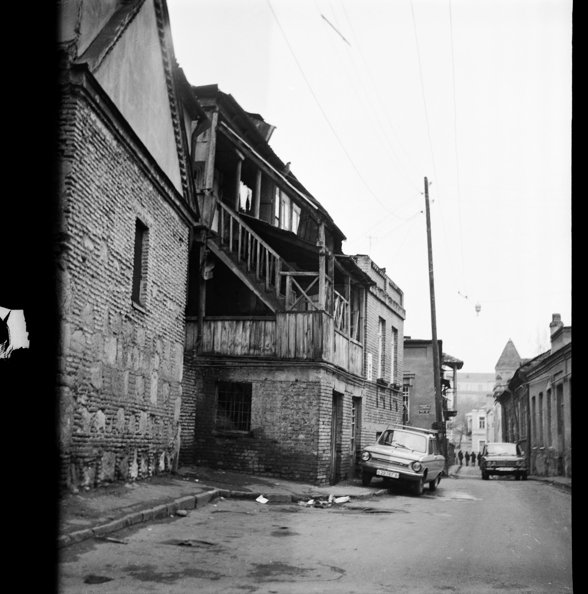 an old black and white photo of a street, by Maurycy Gottlieb, dilapidated house, may 6 8, khreschatyk, sloped street