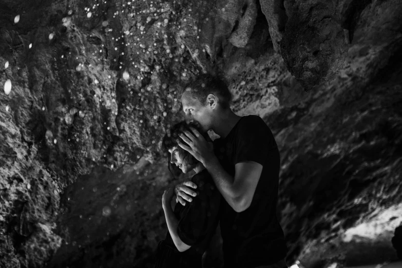 a black and white photo of a man in a cave, a black and white photo, by Giuseppe Avanzi, figuration libre, happy couple, holding close, avatar image, sea
