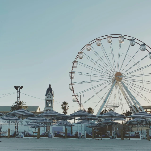 a large ferris wheel sitting in the middle of a parking lot, a picture, pexels contest winner, romanticism, santa monica beach, whitewashed buildings, ariana grande photography, 15081959 21121991 01012000 4k