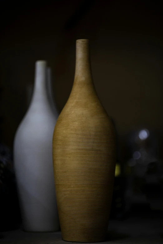 a couple of vases sitting on top of a table, unsplash, photorealism, white wine bottle, curvaceous. detailed, ocher details, low lighting