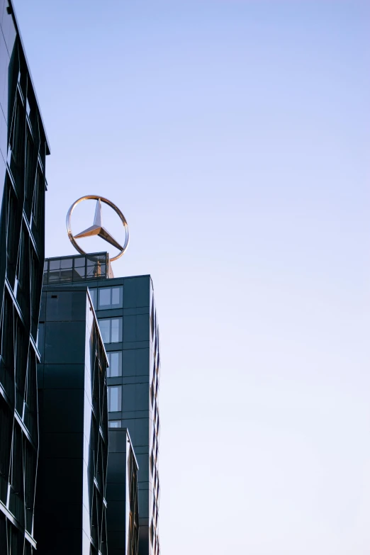 a couple of tall buildings sitting next to each other, by Peter Churcher, unsplash, postminimalism, mercedez benz, peace sign, clear sky, industries