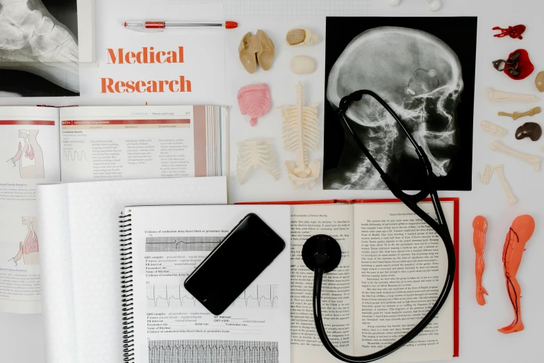 a book sitting on top of a table next to a stethoscope, a portrait, trending on pexels, analytical art, anatomical notes with labels, x ray, in a research facility, poster template on canva