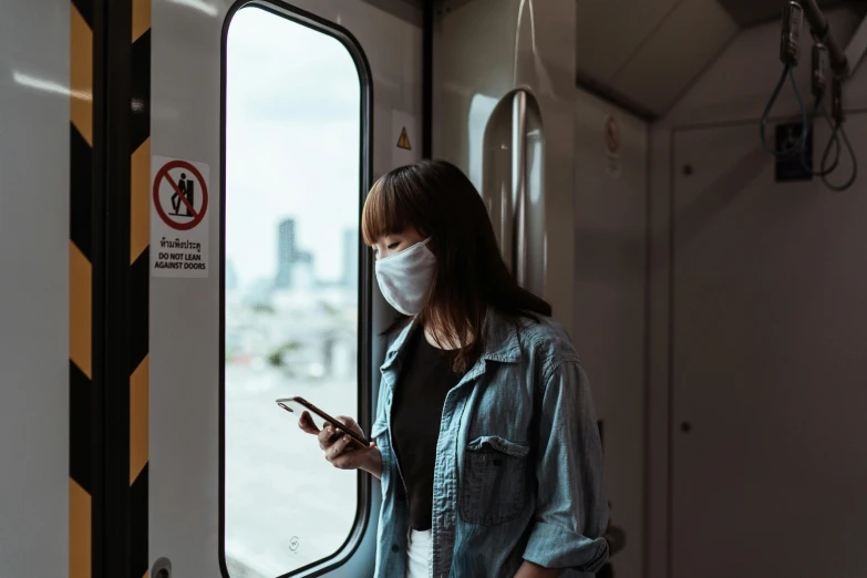 a woman wearing a face mask while looking at her phone, by Adam Marczyński, trending on pexels, train window, scientific, carrying a tray, avatar image