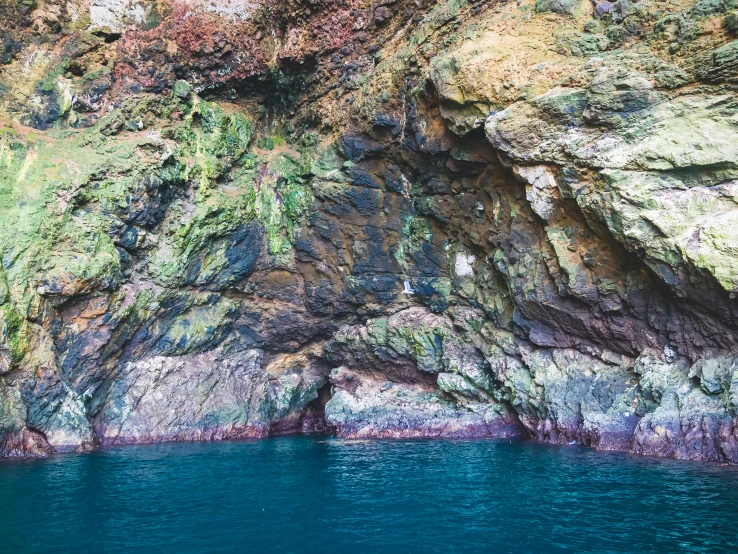 a cave in the middle of a body of water, by Elsa Bleda, unsplash, pembrokeshire, 2 5 6 x 2 5 6 pixels, picton blue, brown