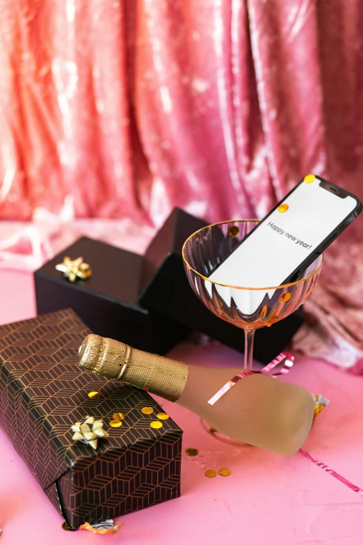 a wine glass sitting on top of a table next to a box, a digital rendering, by Julia Pishtar, happening, dating app icon, drinking champagne, brown and pink color scheme, phone photo