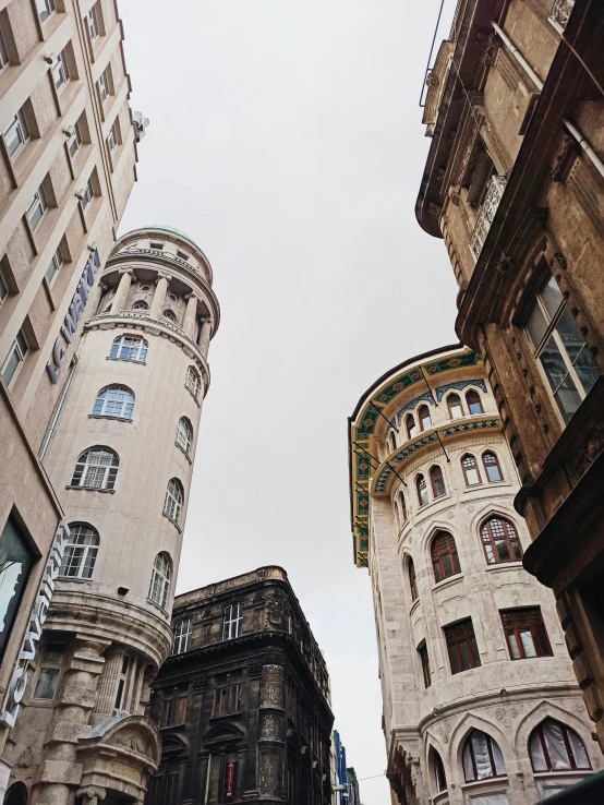 a couple of tall buildings next to each other, by Adam Szentpétery, pexels contest winner, art nouveau, neoclassical tower with dome, low quality photo, alleys, exterior photo