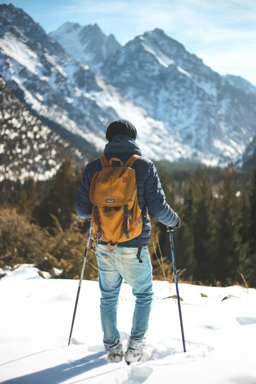 a man riding skis down a snow covered slope, pexels contest winner, hiking clothes, brown, avatar image, schools