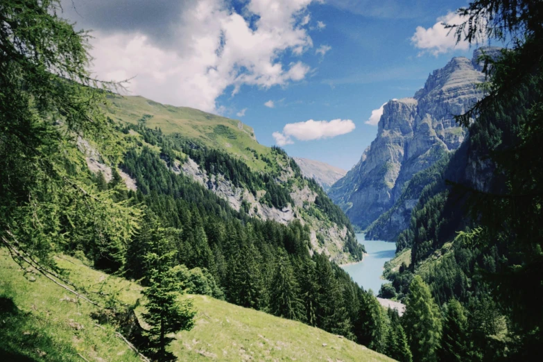 a large body of water sitting on top of a lush green hillside, pexels contest winner, les nabis, lauterbrunnen valley, pine forests, 2 0 0 0's photo, conde nast traveler photo