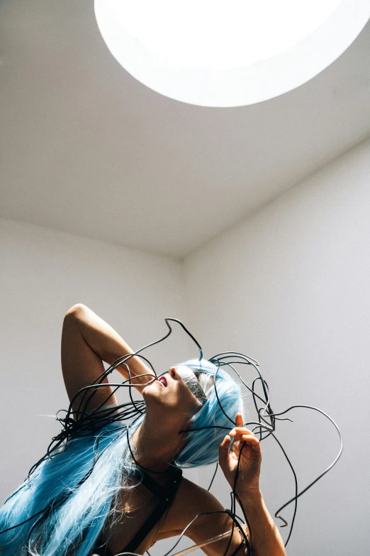 a woman with blue hair in a room, by Nina Hamnett, unsplash, conceptual art, thick wires looping, sun overhead, headbanging, in white room