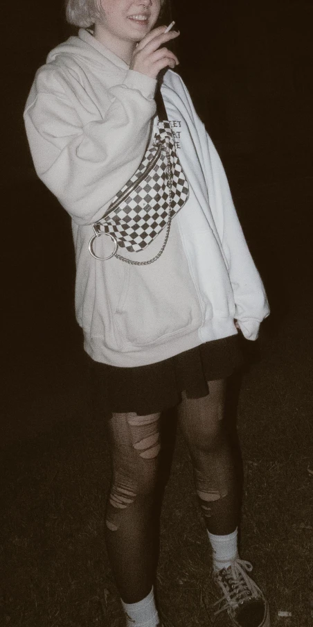 a person that is standing in the grass, she is wearing streetwear, out in the dark, y2k, holding a white flag