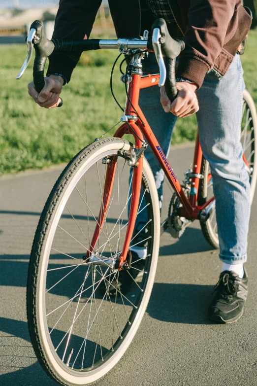 a man riding a red bike down a street, pexels contest winner, closeup of arms, sustainable materials, flat color, 1 2 9 7