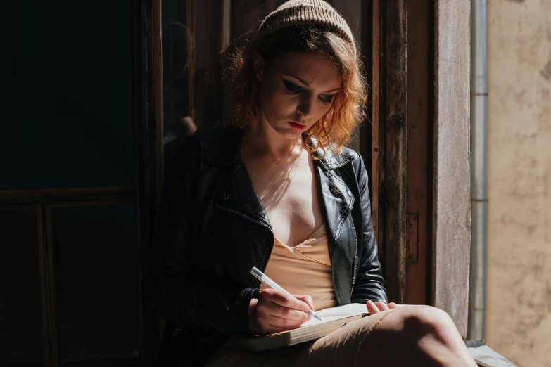a woman sitting on a window sill writing, a portrait, inspired by Elsa Bleda, pexels contest winner, leather clothes, ( redhead, non binary model, notebook