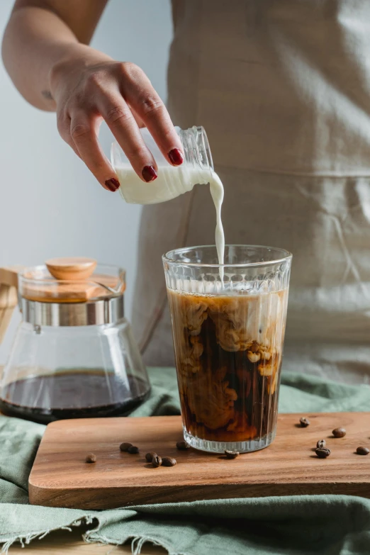 a woman pouring coffee into a glass, by Julia Pishtar, iced latte, square, medium, thumbnail