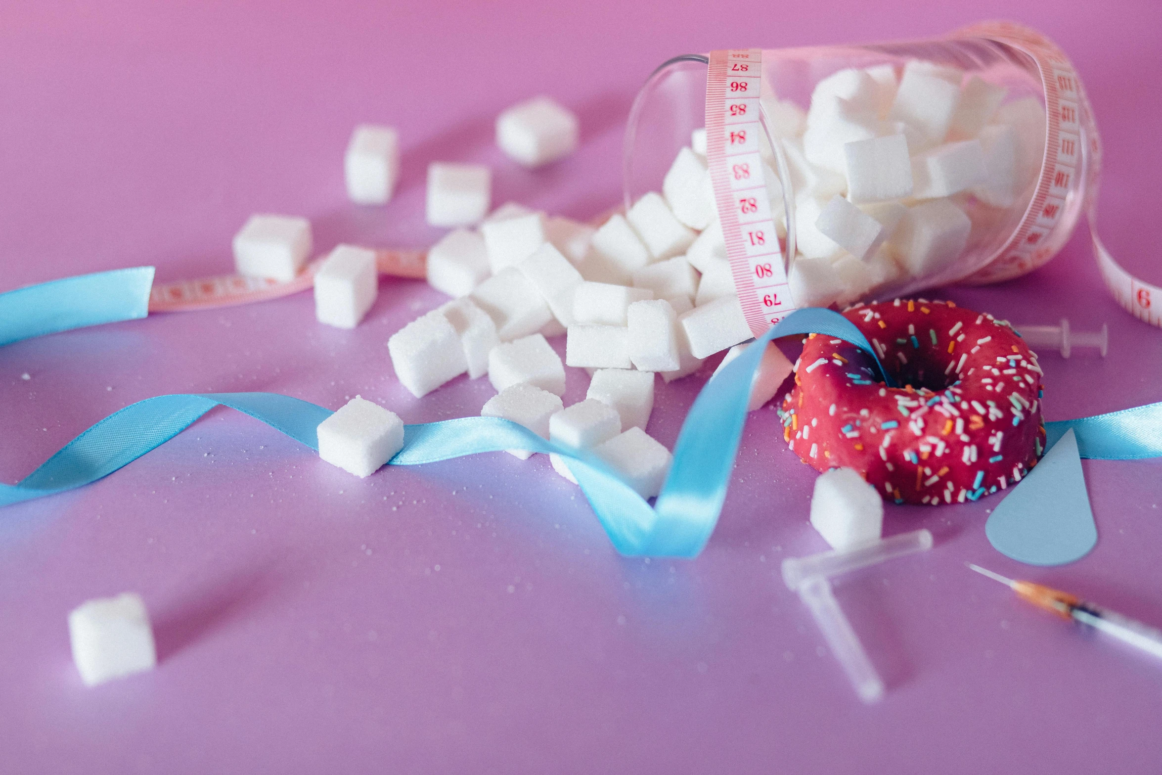 a donut sitting on top of a table covered in sugar cubes, trending on pexels, hyperrealism, ribbon, square, bubblegum, drink