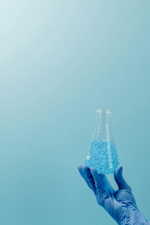 a person holding a flask filled with blue liquid, synthetism, synthetic materials, backdrop, blue, blue diamonds