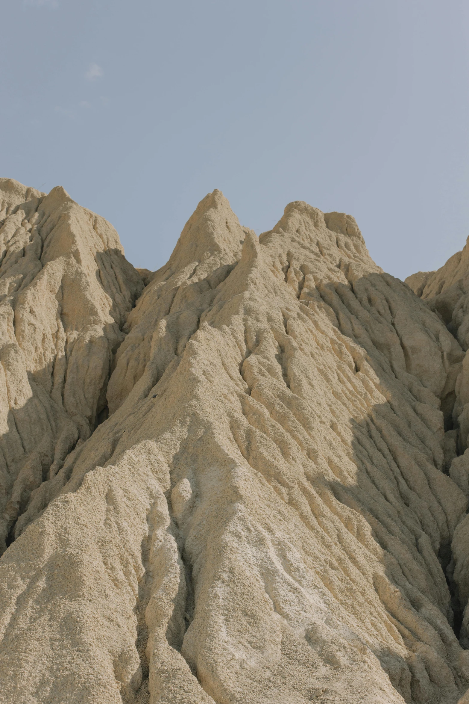 a man riding a snowboard up the side of a mountain, inspired by Zhang Kechun, unsplash, baroque, chiseled formations, sand color, cyprus, grain”