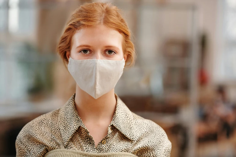 a close up of a person wearing a face mask, a redheaded young woman, wearing a light shirt, beige, fully dressed