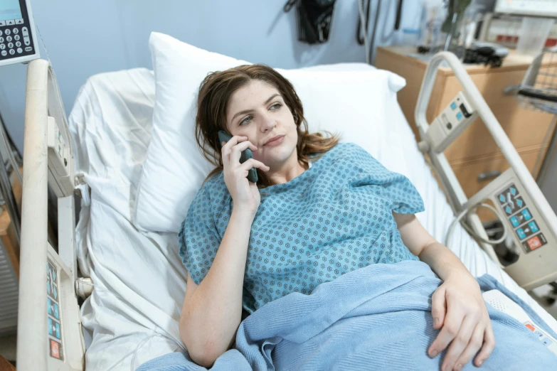 a woman laying in a hospital bed talking on a cell phone, pexels, happening, anna kendrick, fan favorite, cysts, pregnant