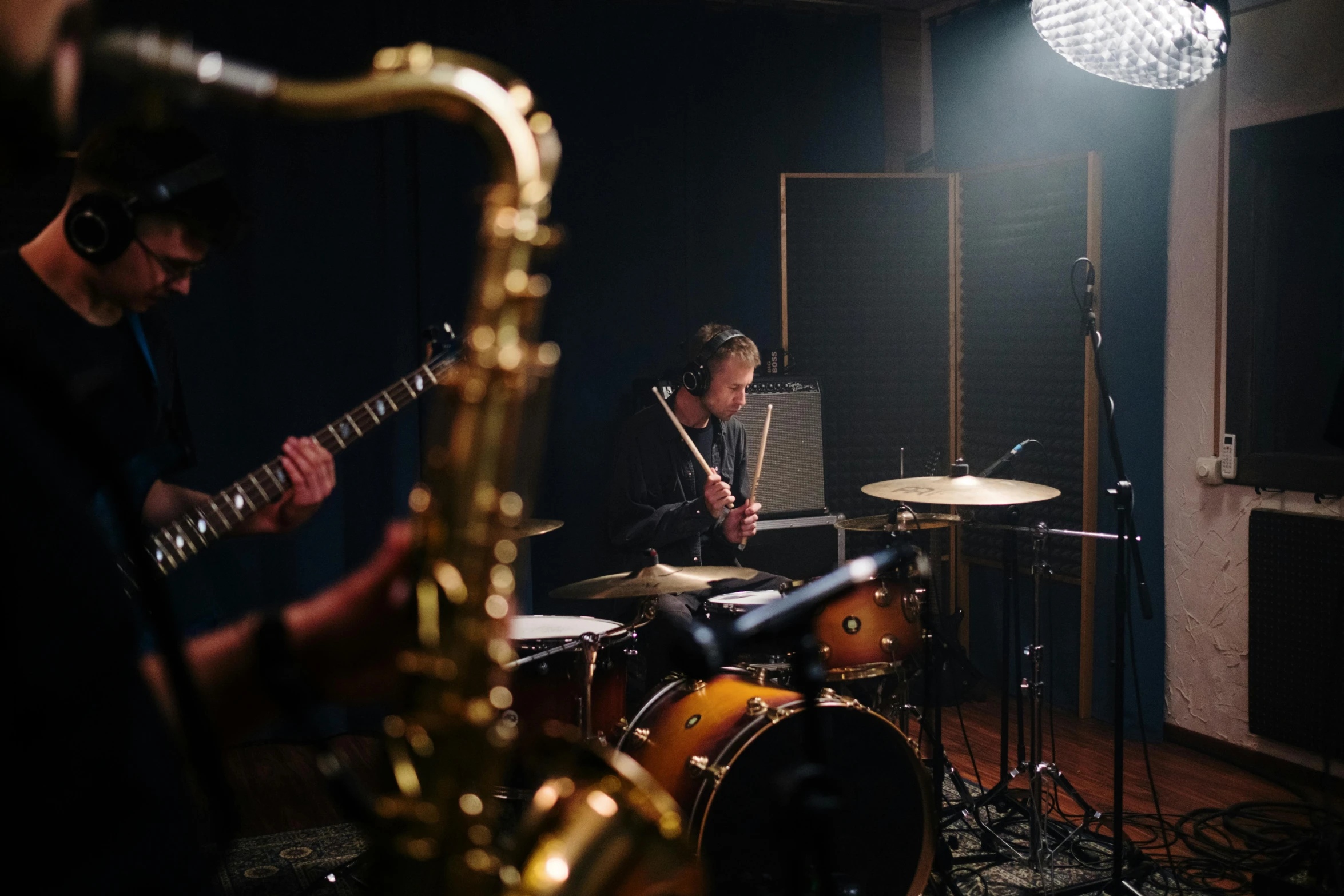 a group of people playing instruments in a room, unsplash, photorealism, studio recording, **cinematic, 3 / 4 wide shot, drumkit