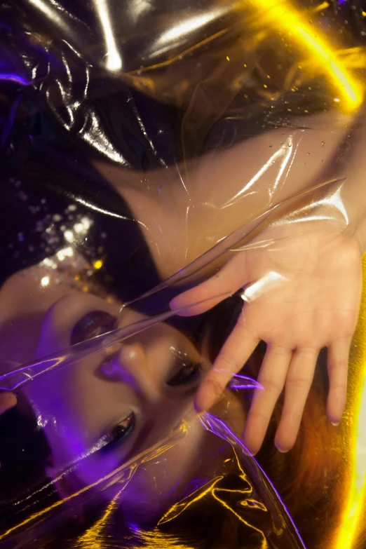 a close up of a person in a plastic bag, an album cover, inspired by Nan Goldin, unsplash, aestheticism, draped in purple and gold silk, cybernetic hands, wearing atsuko kudo latex outfit, 奈良美智