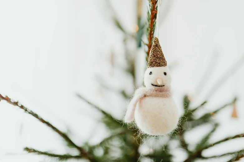 a snowman ornament hanging from a christmas tree, inspired by Ernest William Christmas, trending on pexels, folk art, wool felting art, silver，ivory, 35 mm product photo”, golden ornaments