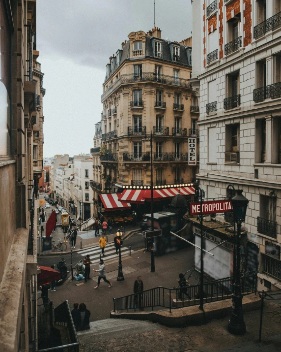 a group of people walking down a street next to tall buildings, pexels contest winner, paris school, storefronts, overview, a quaint, lgbtq