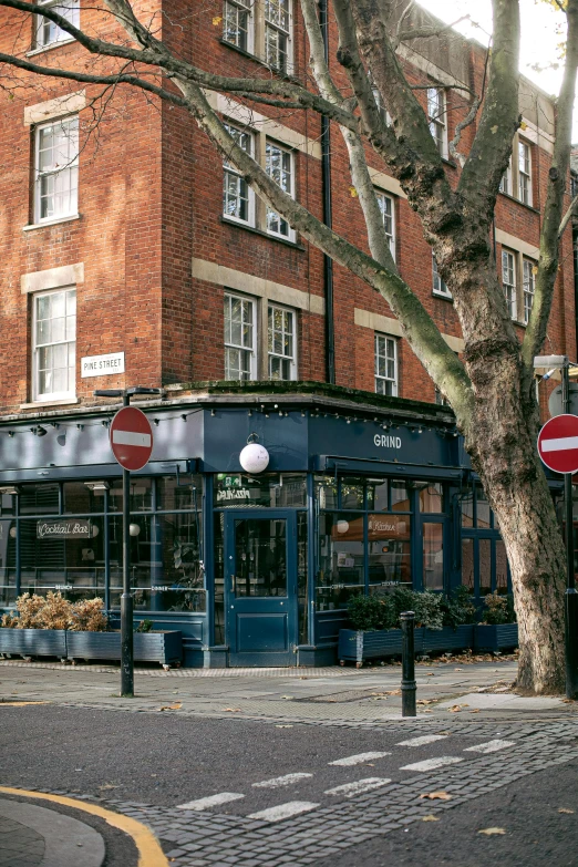 a red stop sign sitting on the side of a road, inspired by Richmond Barthé, art nouveau, stood outside a corner shop, blue, cafe tables, london architecture