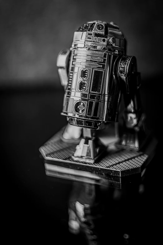 a toy robot sitting on top of a table, a black and white photo, unsplash, photorealism, star wars imperial style, close - up profile, sci - fi jewellery, high angle close up shot