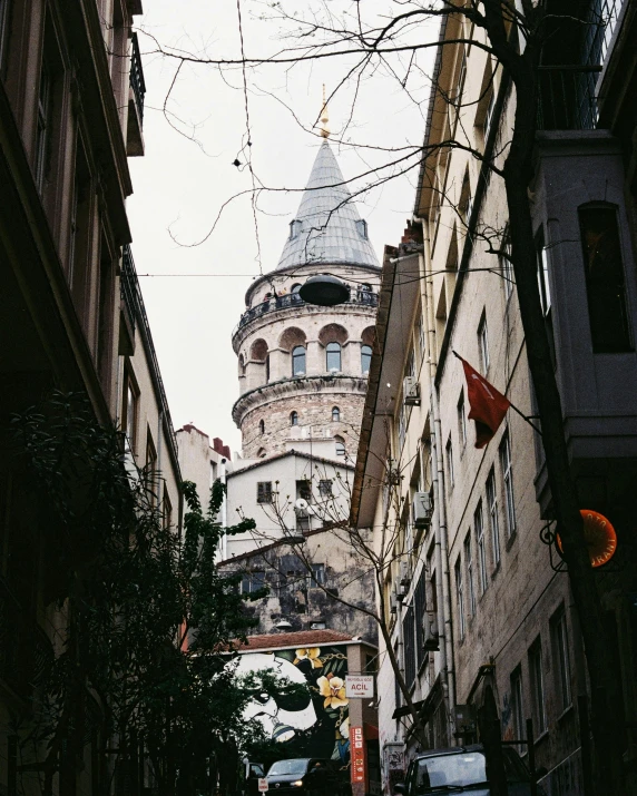 a narrow street with a clock tower in the background, by Cafer Bater, unsplash contest winner, art nouveau, istanbul, neoclassical tower with dome, grey, gif