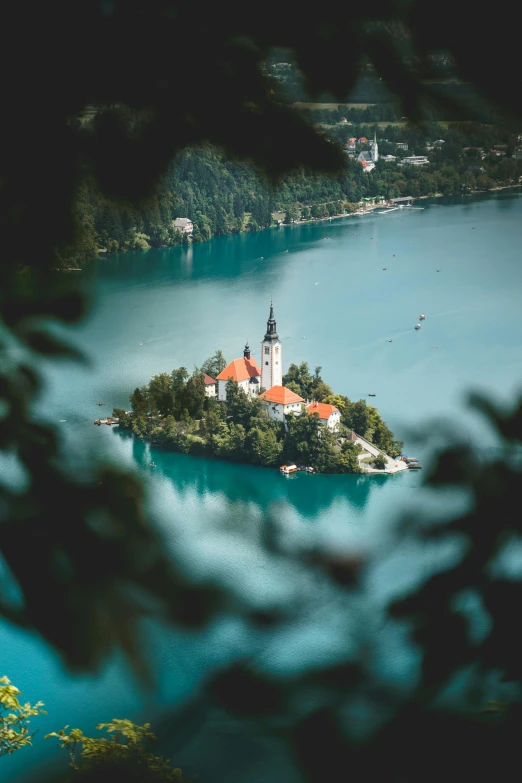 a small island in the middle of a lake, by Sebastian Spreng, unsplash contest winner, slovenian, city buildings on top of trees, blue and green water, floating crown