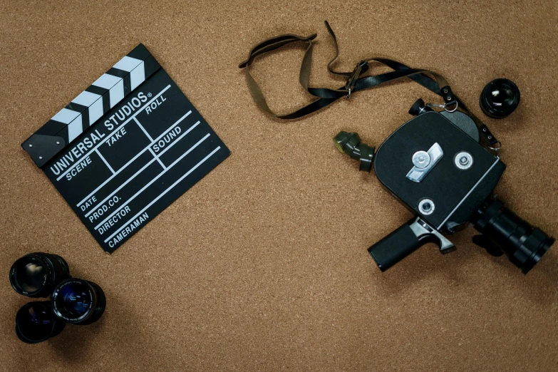 a close up of a camera and a movie clapper, inspired by roger deakins, pexels contest winner, cardboard, aerial shot, story board format, camera on the ground