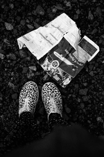 a person standing next to a newspaper on the ground, a black and white photo, by Anato Finnstark, sneaker photo, rocky roads, ((still life)), ffffound