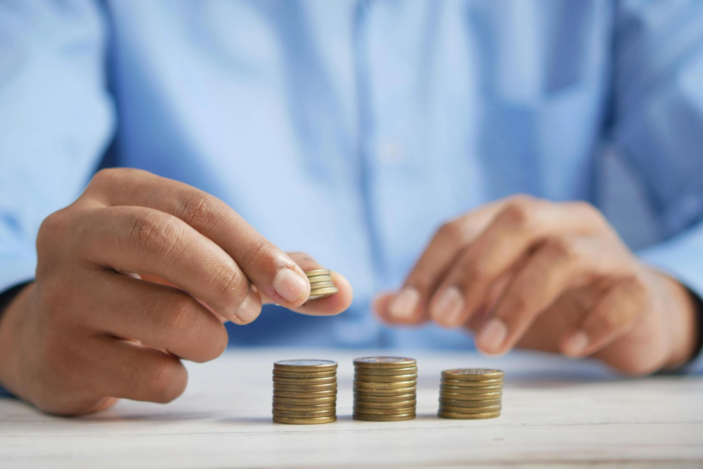 a man putting coins into a stack on a table, trending on pexels, hurufiyya, three quater notes, realistic image, ad image, 7 0 s photo