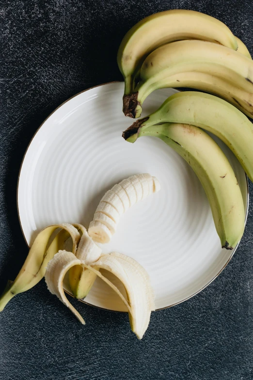 a bunch of bananas sitting on top of a white plate, detailed product image, curved blades on each hand, a pair of ribbed, botanical