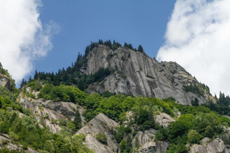 a group of people standing on top of a lush green hillside, rock climbing, seen from a distance, chamonix, today\'s featured photograph 4k