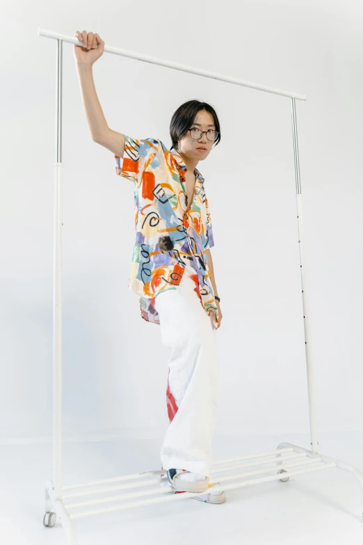 a man that is standing in front of a rack, inspired by Russell Dongjun Lu, unsplash, gutai group, with hawaiian shirt, wearing off - white style, woman posing, multicolored