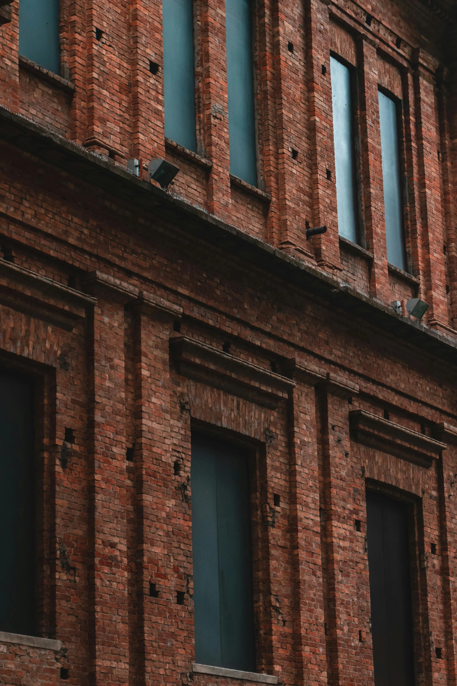 a clock that is on the side of a building, by Adam Marczyński, pexels contest winner, brick building, brown holes, shot from a distance, low quality photo