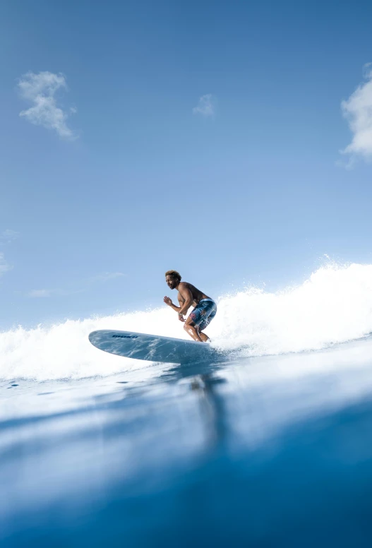 a man riding a wave on top of a surfboard, sigma 55”, blue, reefs, pristine and clean