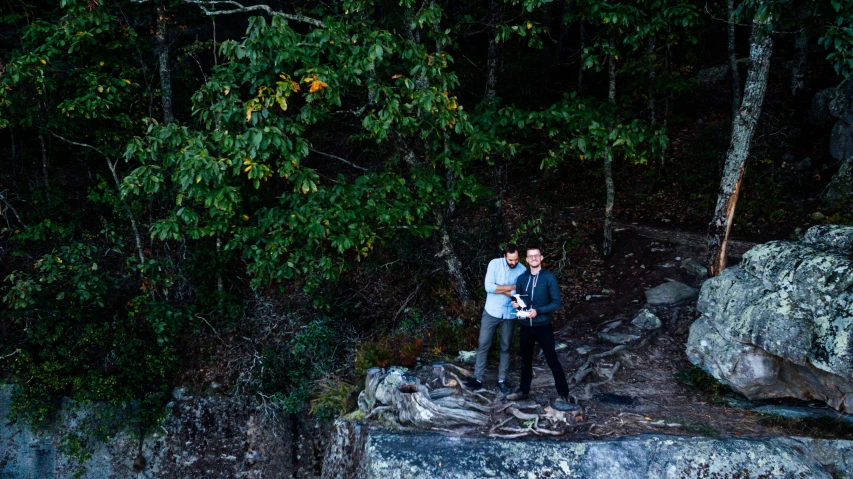 a man and a woman standing on a rock in the woods, conde nast traveler photo, drone photo, bowater charlie and brom gerald, jeremy lipkin and rob rey