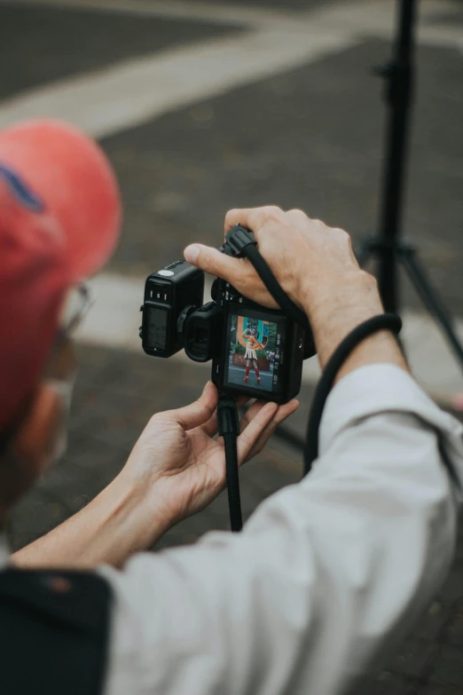 a person taking a picture with a camera, pointing at the camera, posing for the camera, looking down on the camera