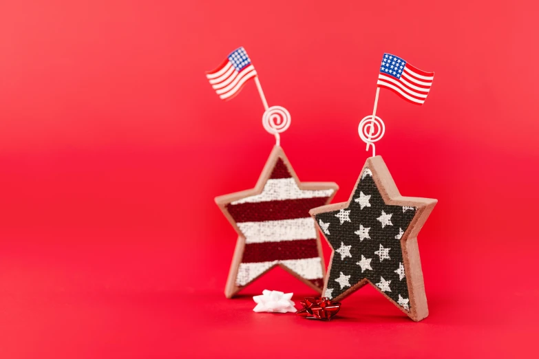 two stars with american flags sticking out of them, pexels, folk art, on a red background, candy decorations, cardboard, photo of