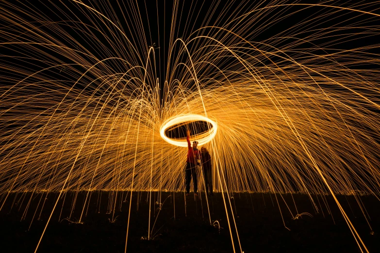 a man standing in front of a ring of fire, by Sebastian Spreng, pexels contest winner, golden spirals, shafts of lighting, outdoor photo, lighting her with a rim light