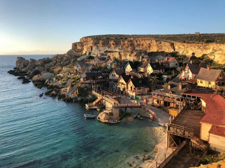 a group of houses sitting on top of a cliff next to the ocean, glowy light, historical setting, flatlay, slide show